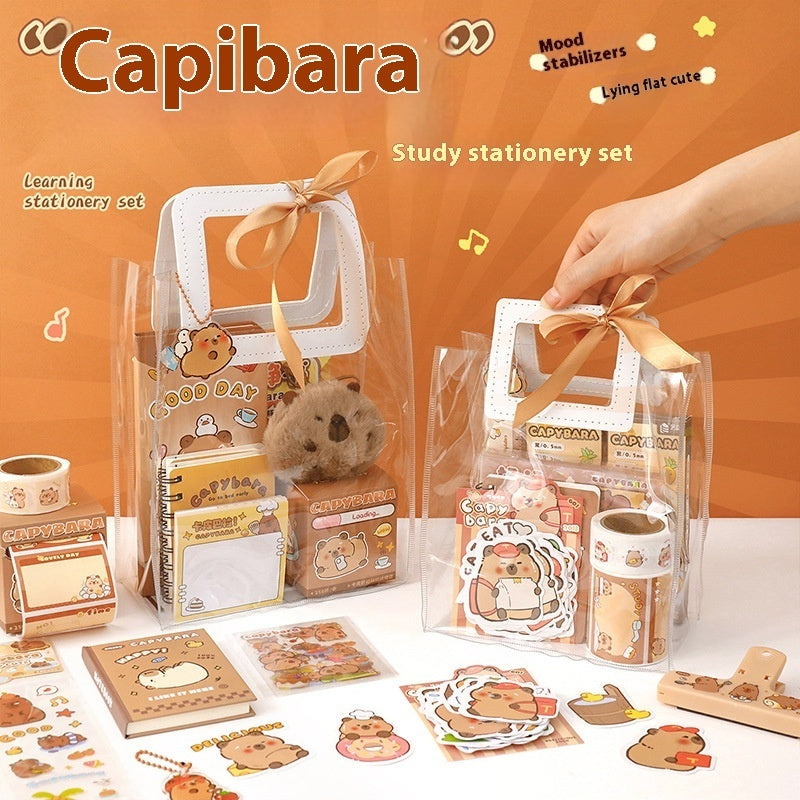 Capibara-themed study stationery set with a hand holding a clear bag containing stationery items on an orange background.